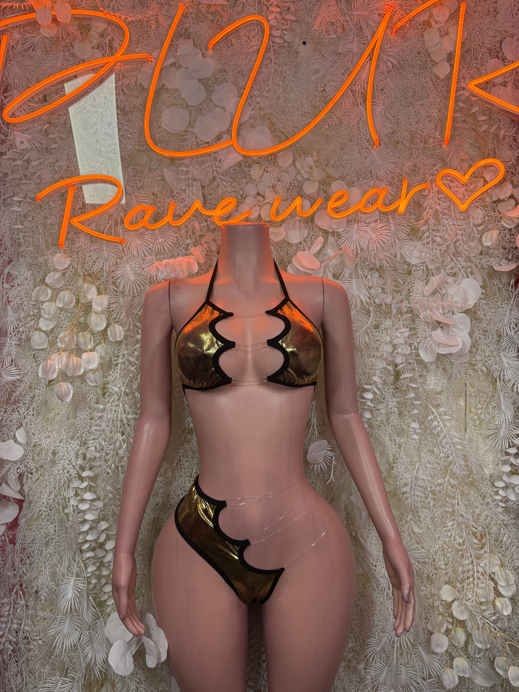 Black and gold cutout bikini set with halter top and high-leg bottoms on mannequin