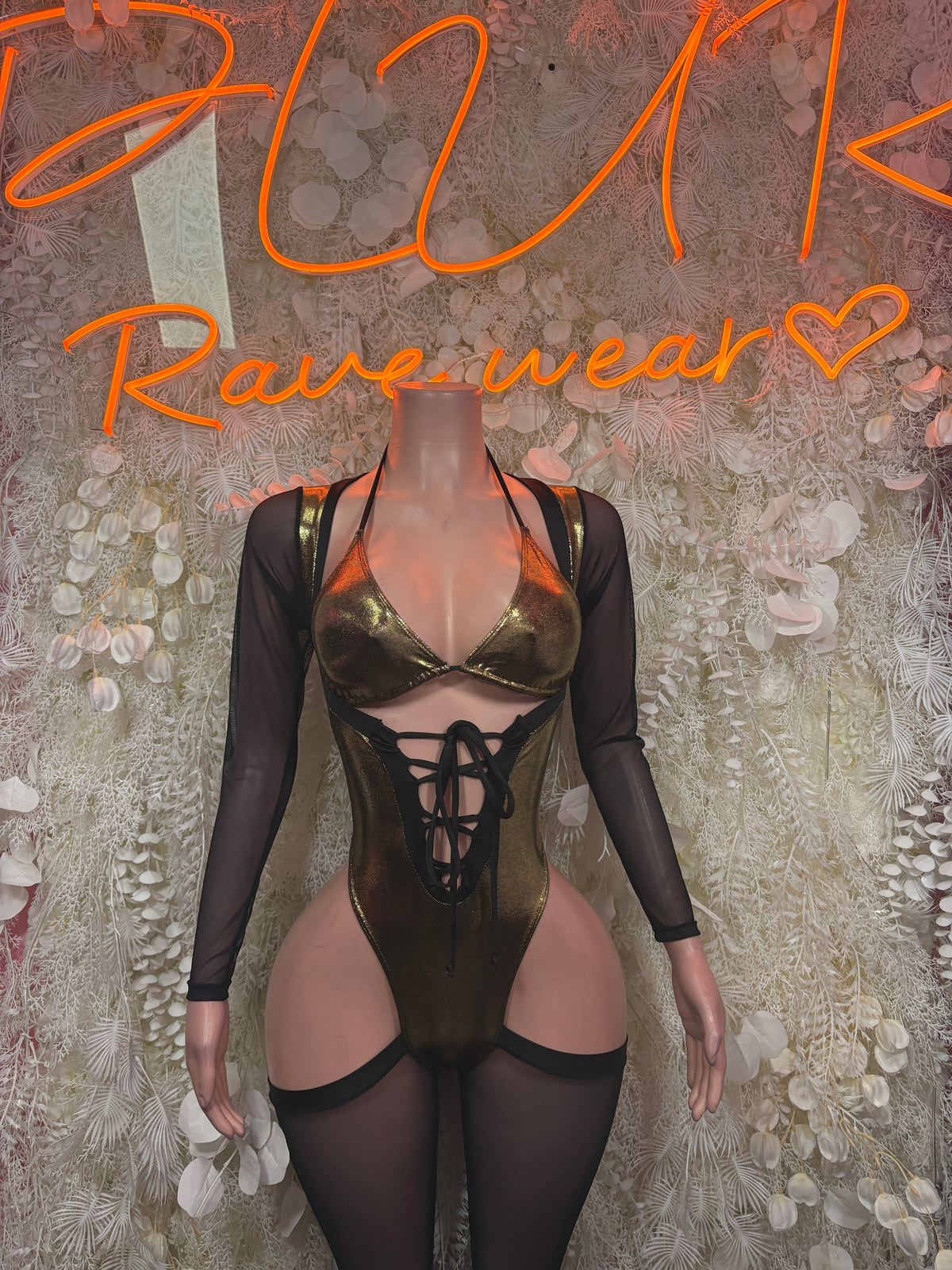 Black sheer long-sleeve bodysuit with metallic gold bra top and lace-up front cutouts
