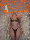 Black thong-style bodysuit with gold triangle cups and tasseled halter straps