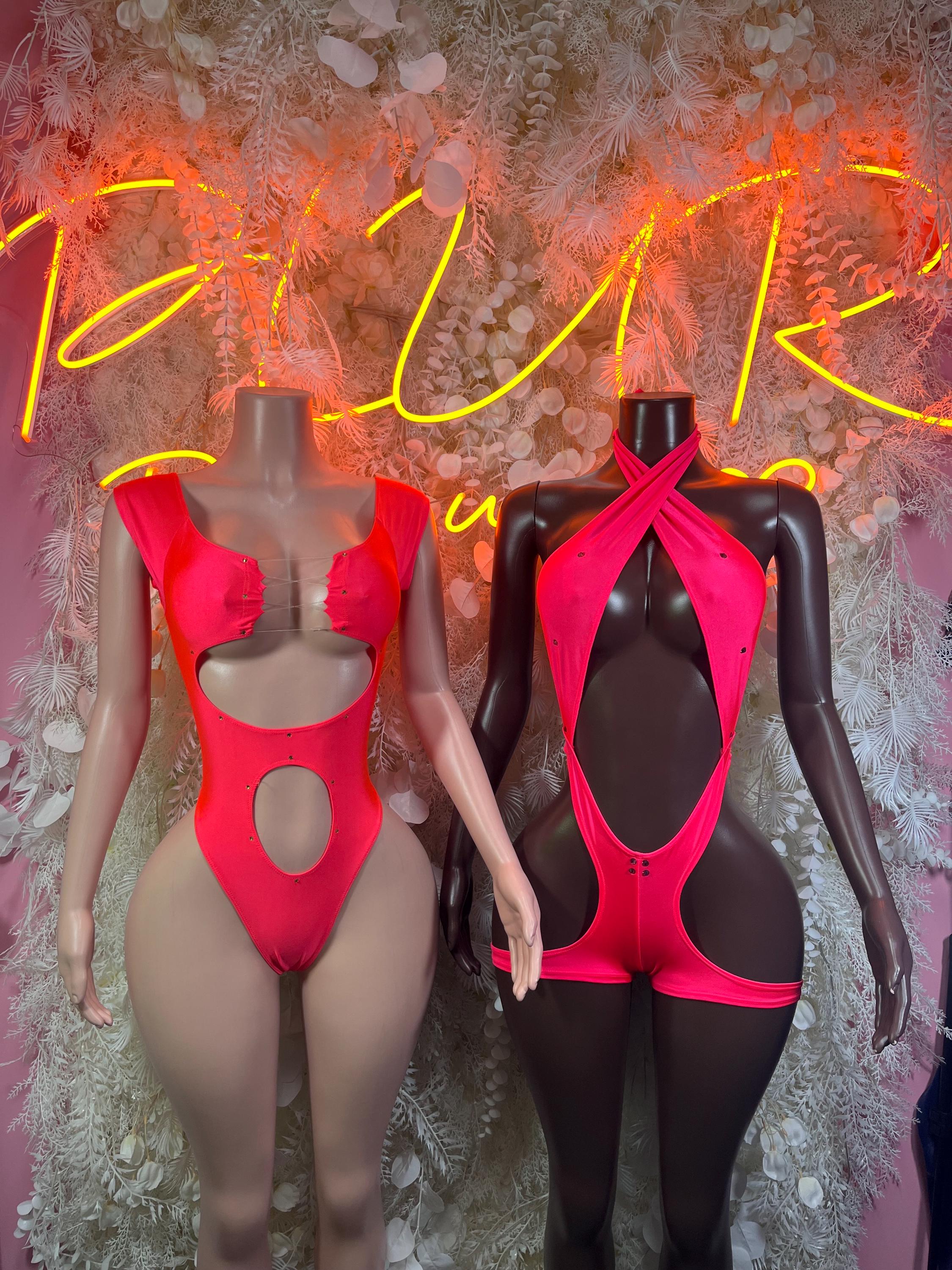Two cutout one-piece bodysuits on mannequins: bright red and red/black, chest cutouts