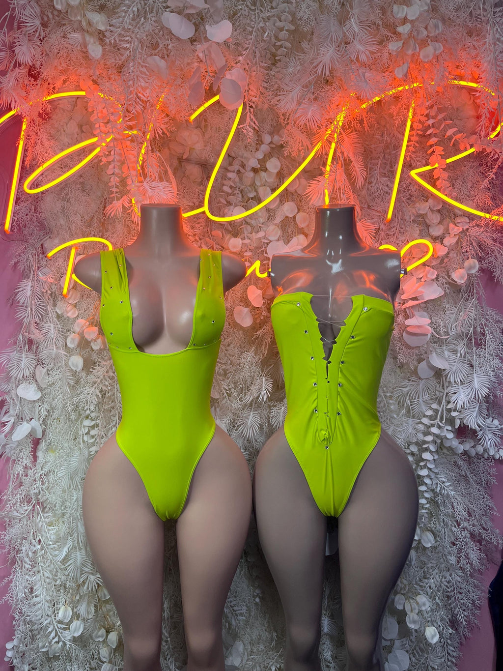 Neon green one-piece bodysuit with cutout back, zipper front, and high-cut legs