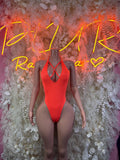 Neon orange halter one-piece bodysuit with oval chest cutout and cheeky legs