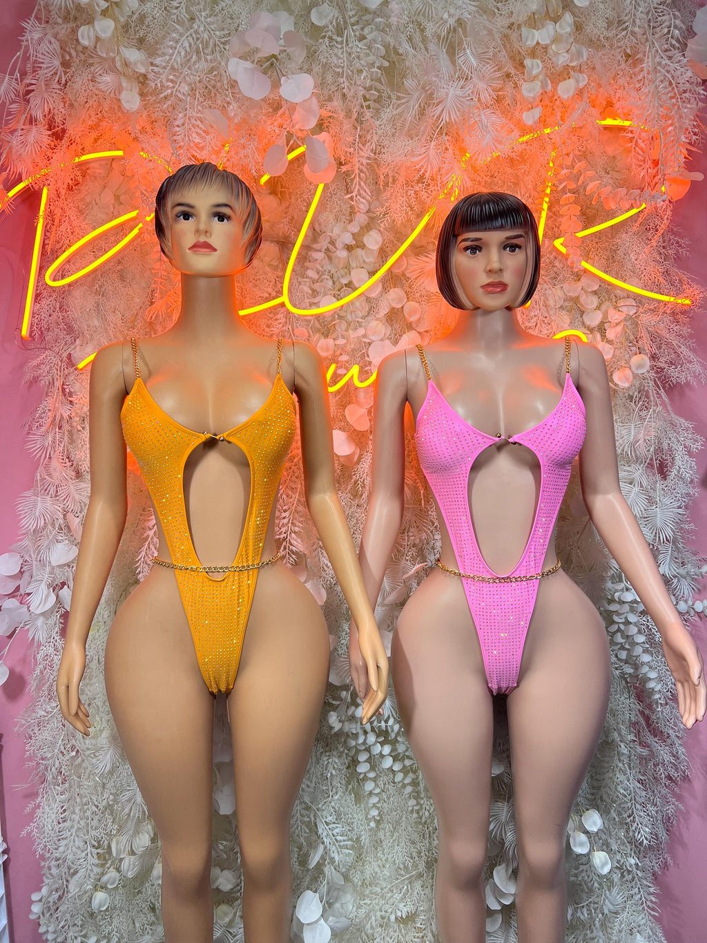 One-piece rhinestone bodysuits: orange left, pink right, V-cut front
