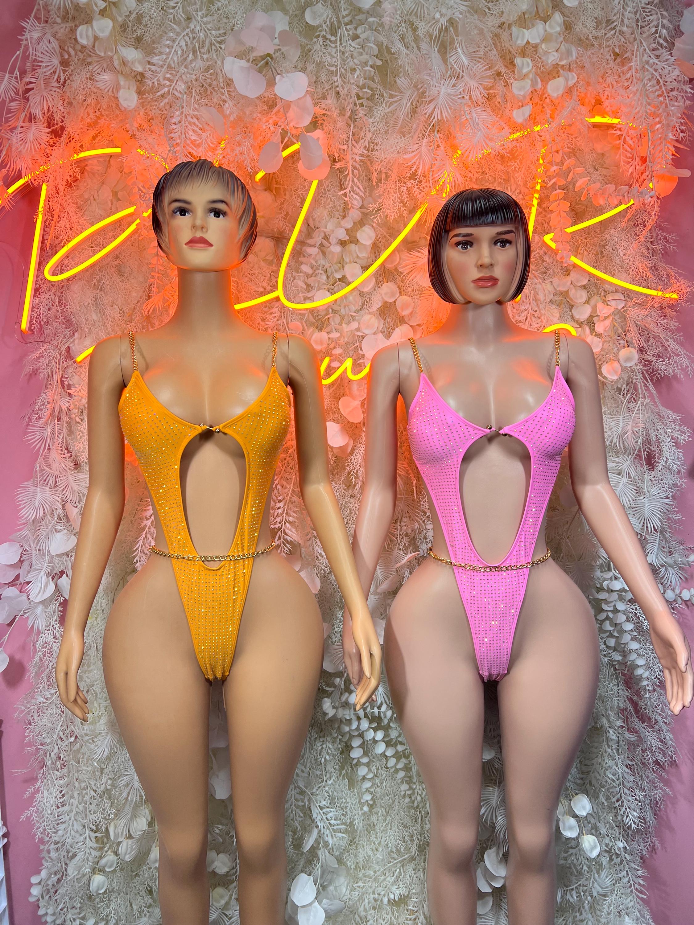 One-piece rhinestone bodysuits: orange left, pink right, V-cut front