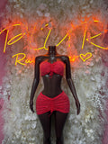 Red rhinestone strapless crop top with bow and matching mini skirt on mannequin