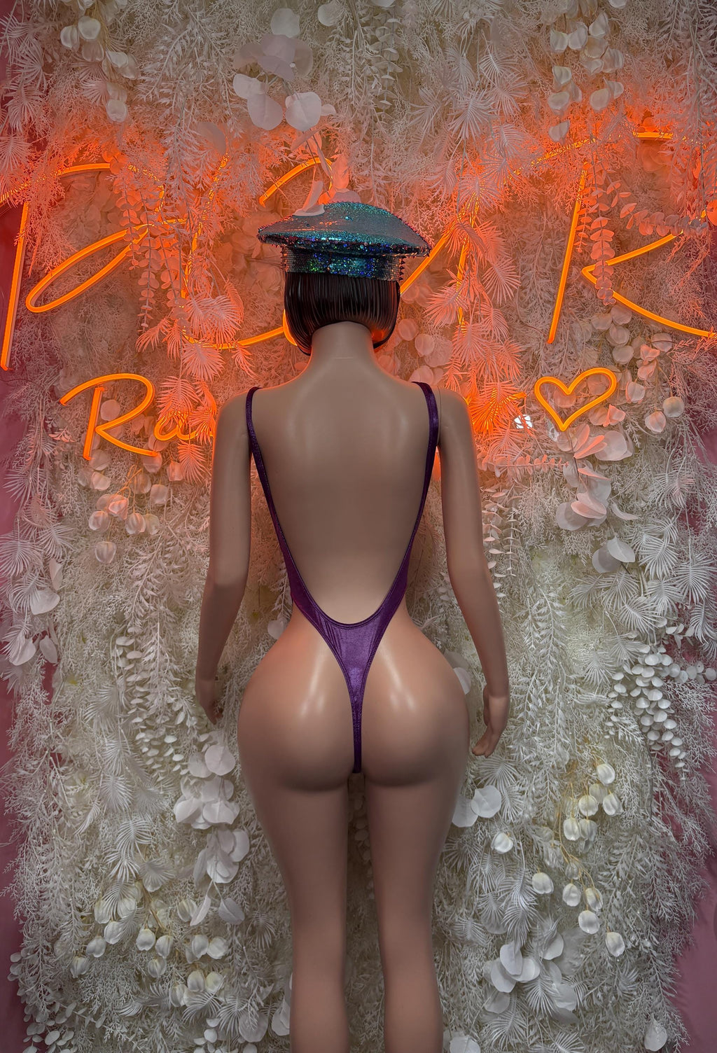 Purple one-piece bodysuit with open back and matching sequin cap