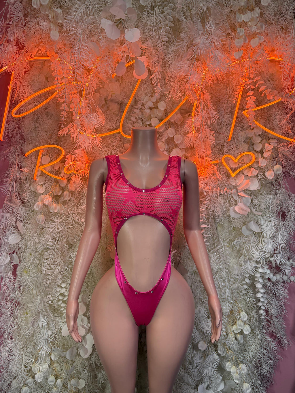 Pink mesh bodysuit with scoop neckline, open midriff cutout, and high-leg bottom
