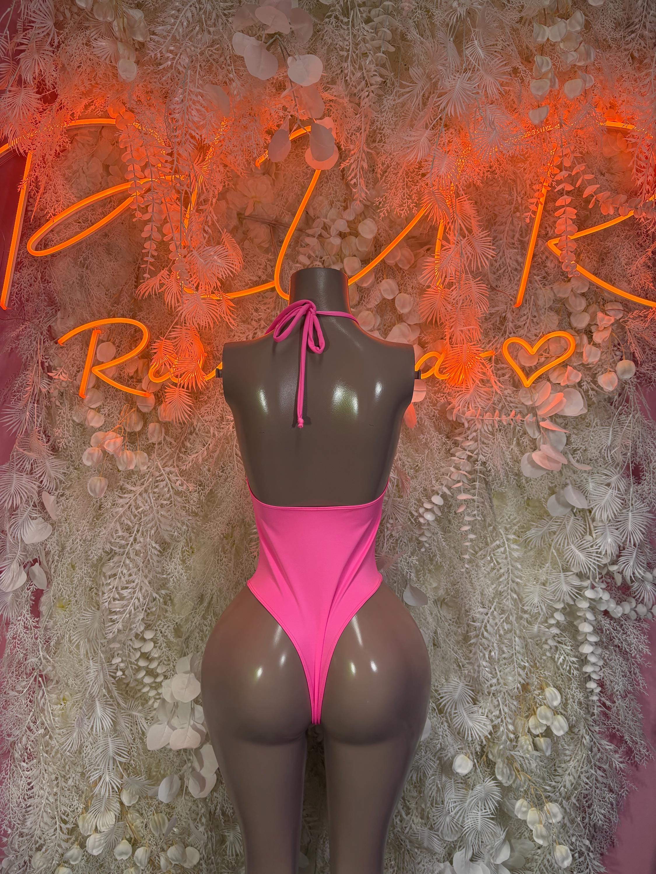Pink one-piece bodysuit with halter tie, open back, high-leg cut, sheer mesh