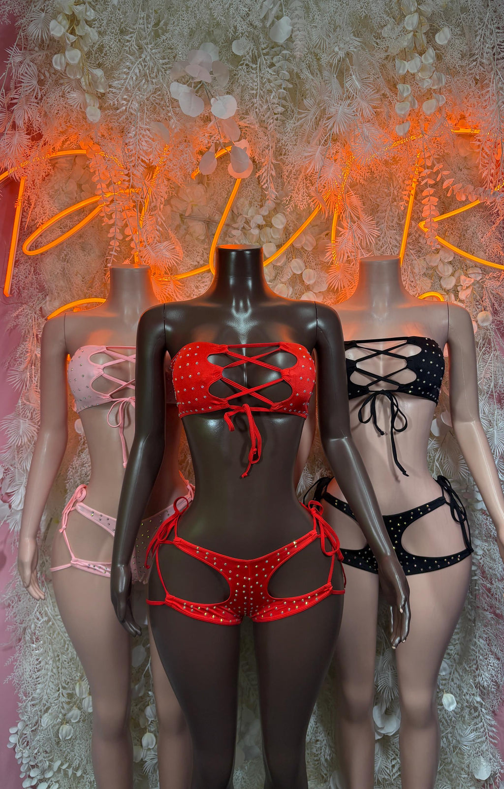 Pink and dark two-piece rhinestone festival bodysuits, front group view with bows