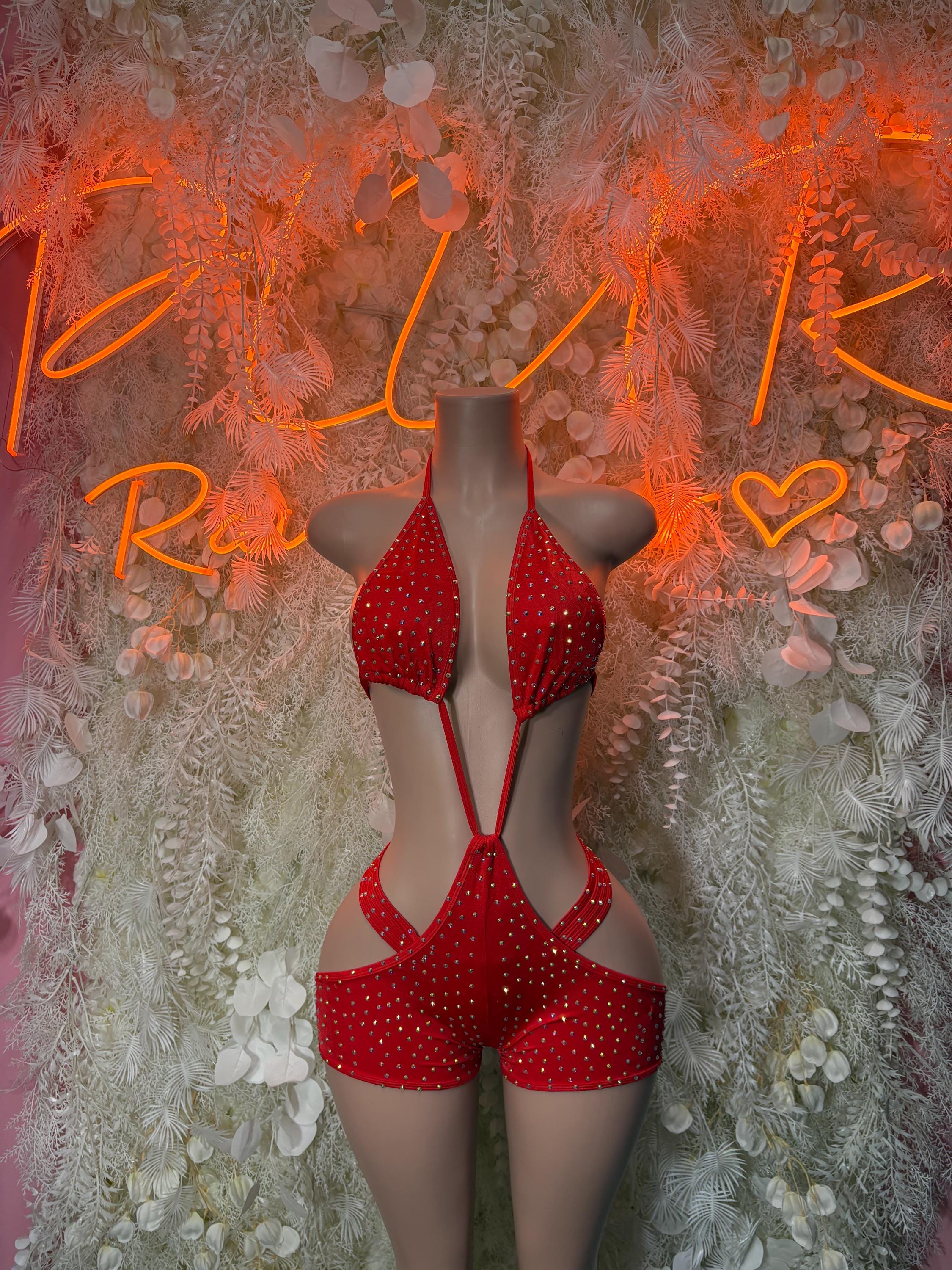 Red rhinestone halter bodysuit with crisscross straps and high-cut shorts