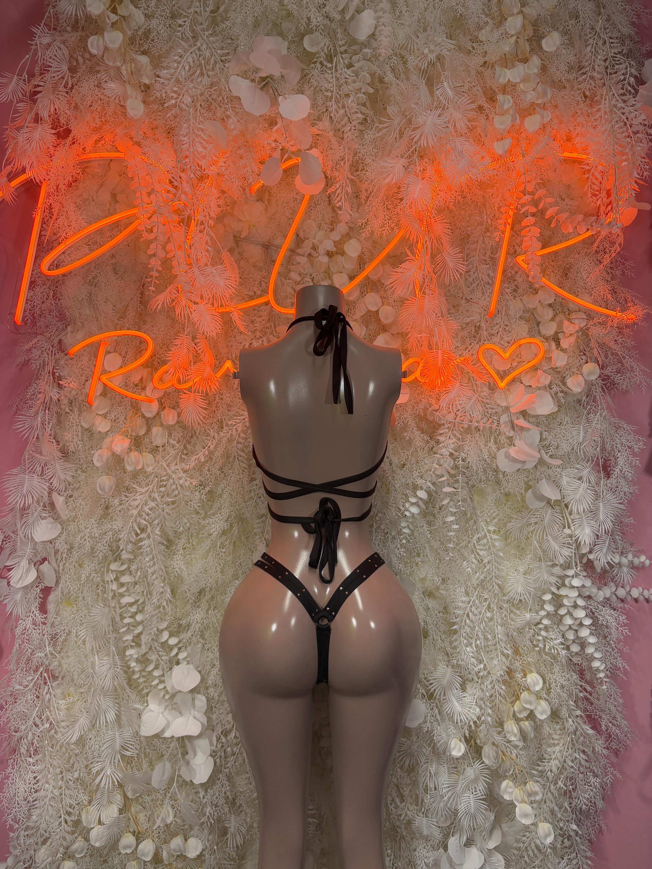 Black strappy bikini with back tie bow, halter straps, and crisscross cutouts