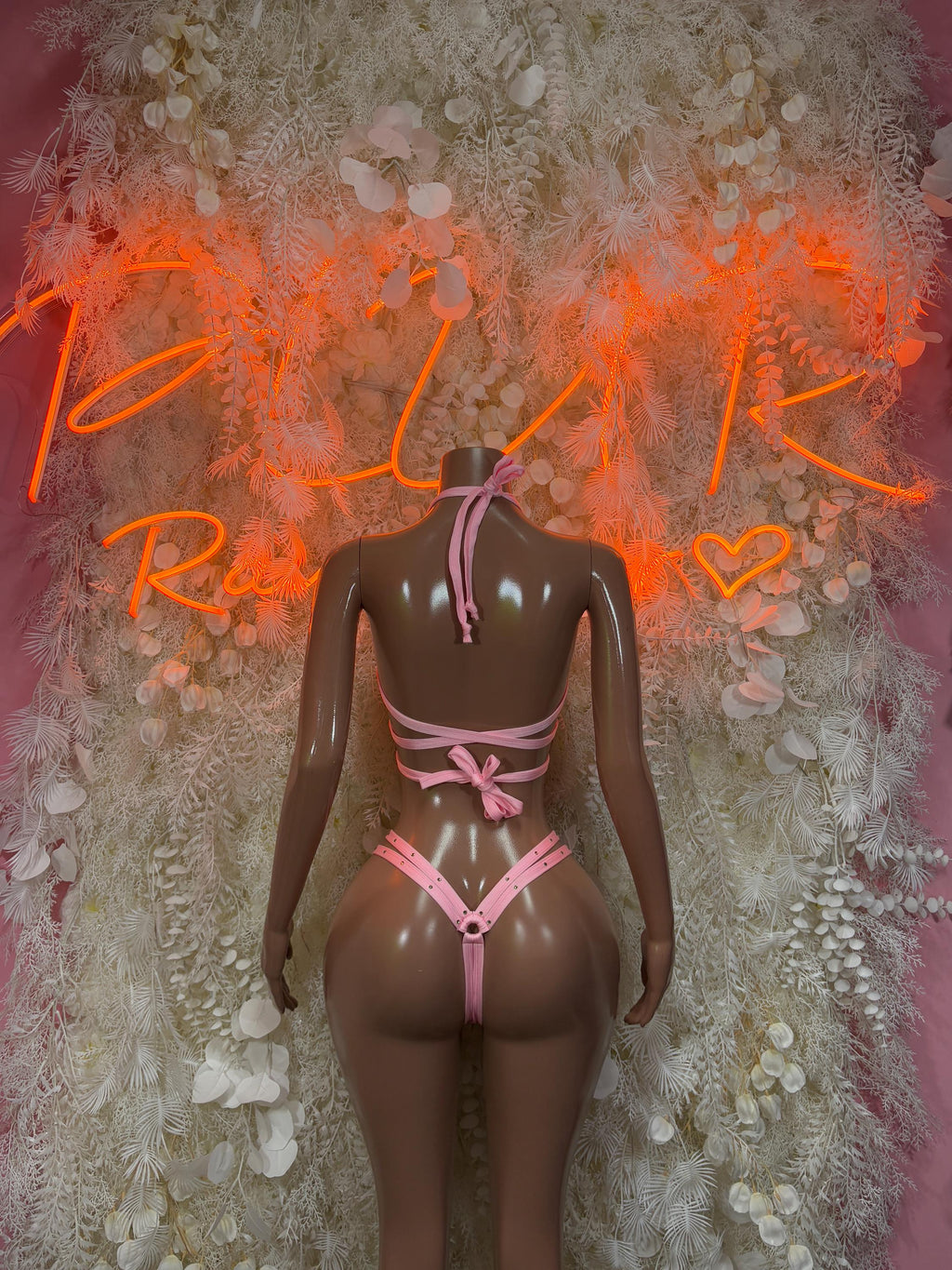 Pink strappy rave one-piece bikini on mannequin, crisscross back straps