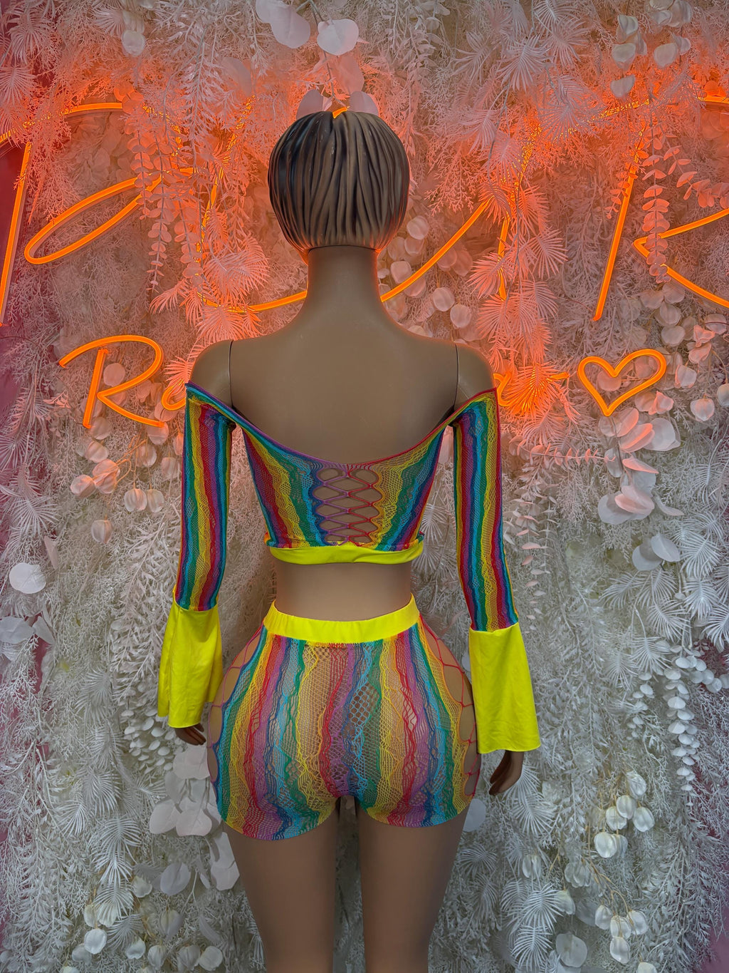 Back view rainbow iridescent fishnet romper with bell sleeves and neon waist trim
