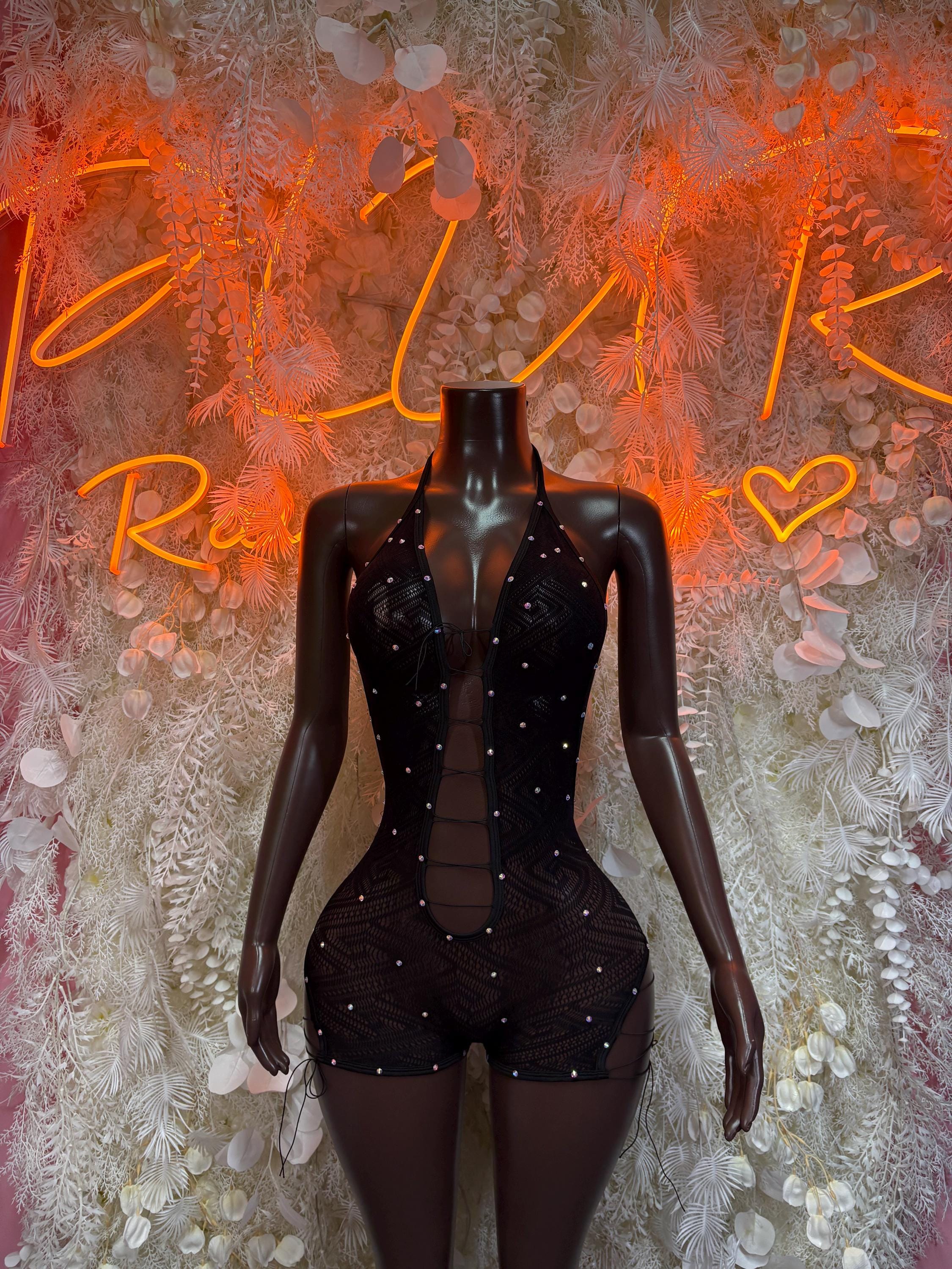 Black one-piece corset bodysuit with sheer sleeves and short bottoms