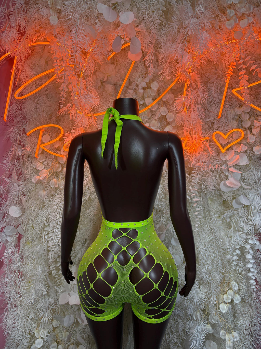 Green fishnet bodysuit back view with ladder-style straps and thong leg openings