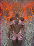 Pink rhinestone rave bodysuit set with off-shoulder sleeves and cutout shorts