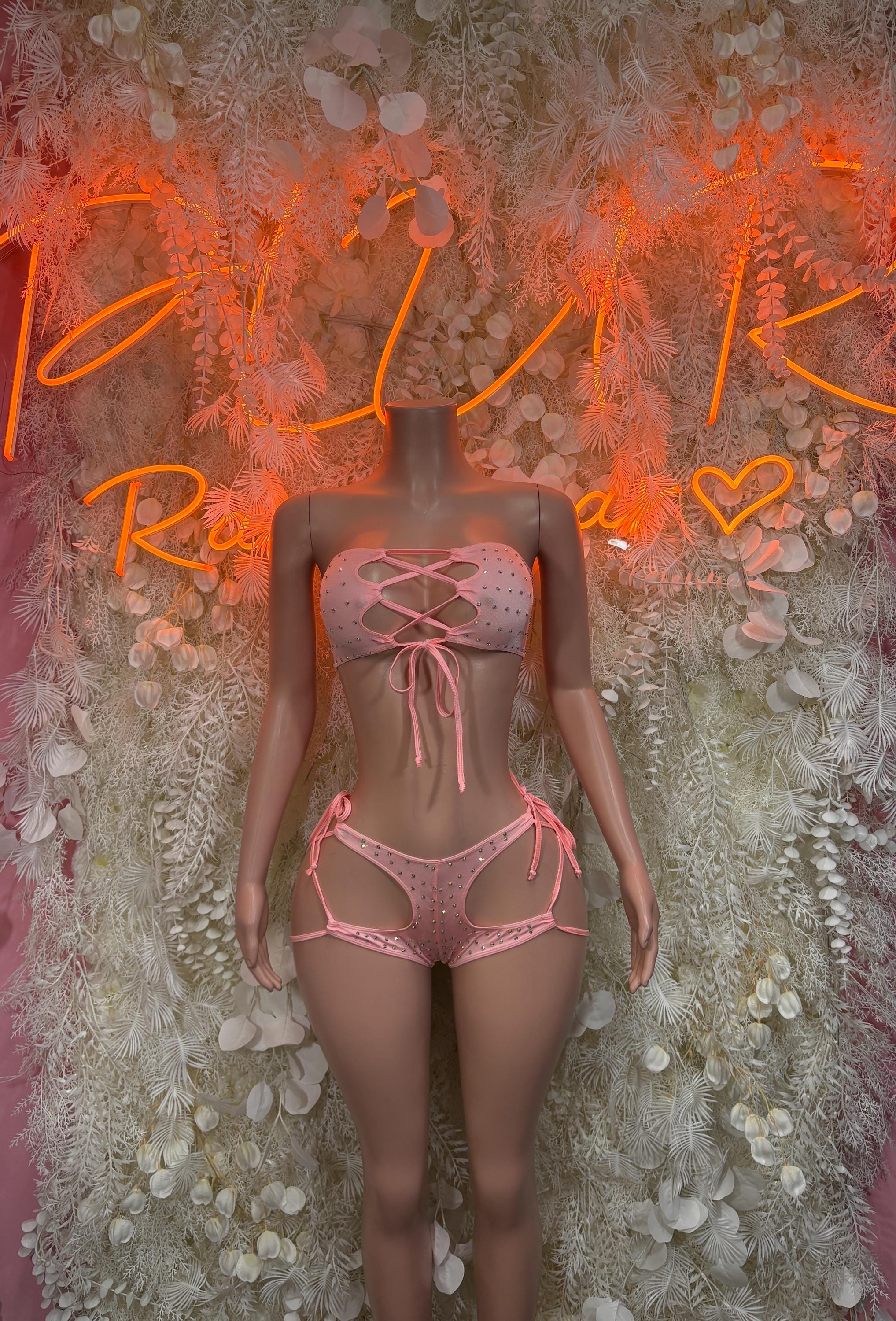 Pink rhinestone two-piece festival bodysuit, front view with crisscross strap detailing