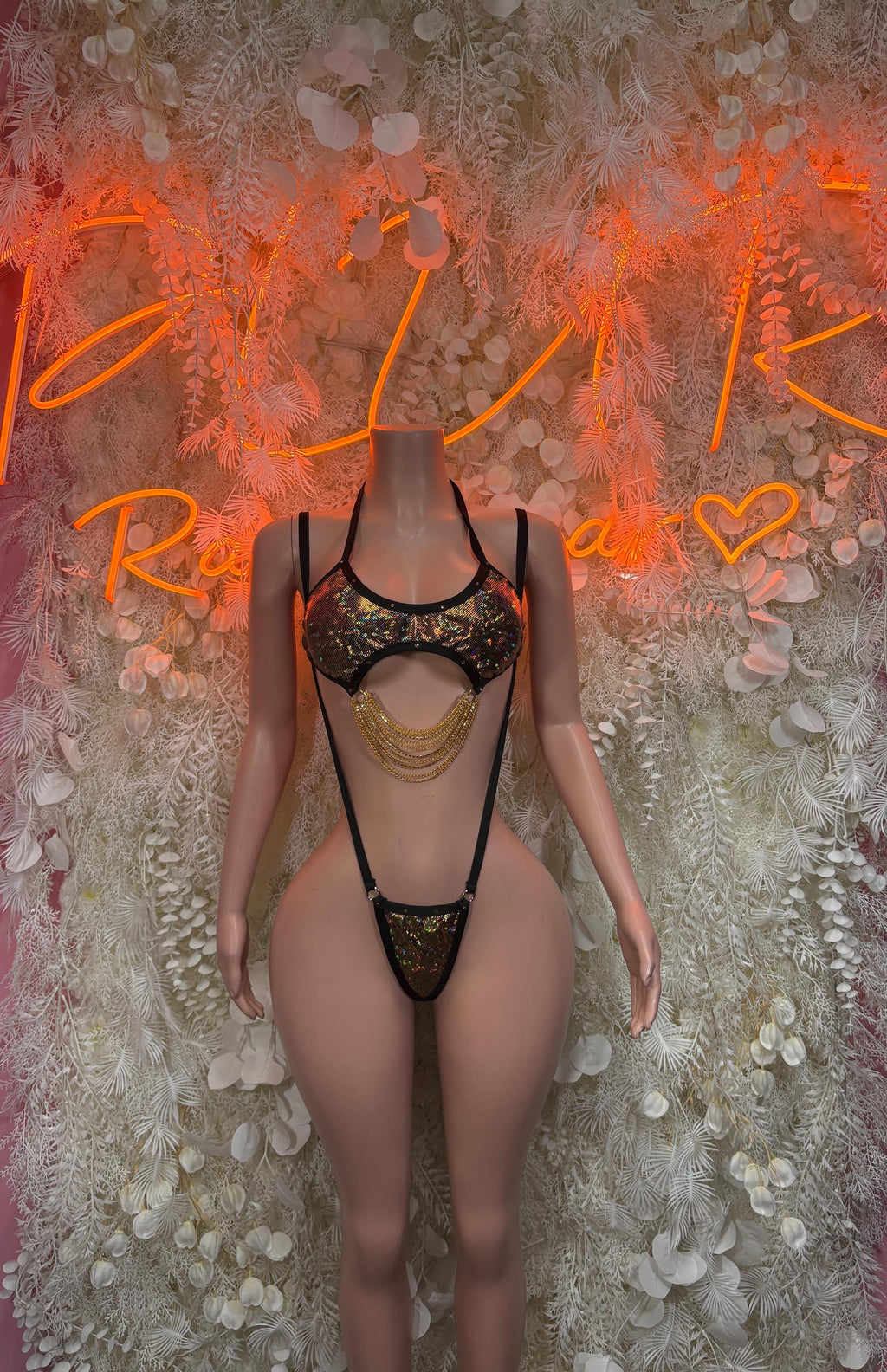 Black rhinestone one-piece bodysuit with gold chain detail and thong cutout