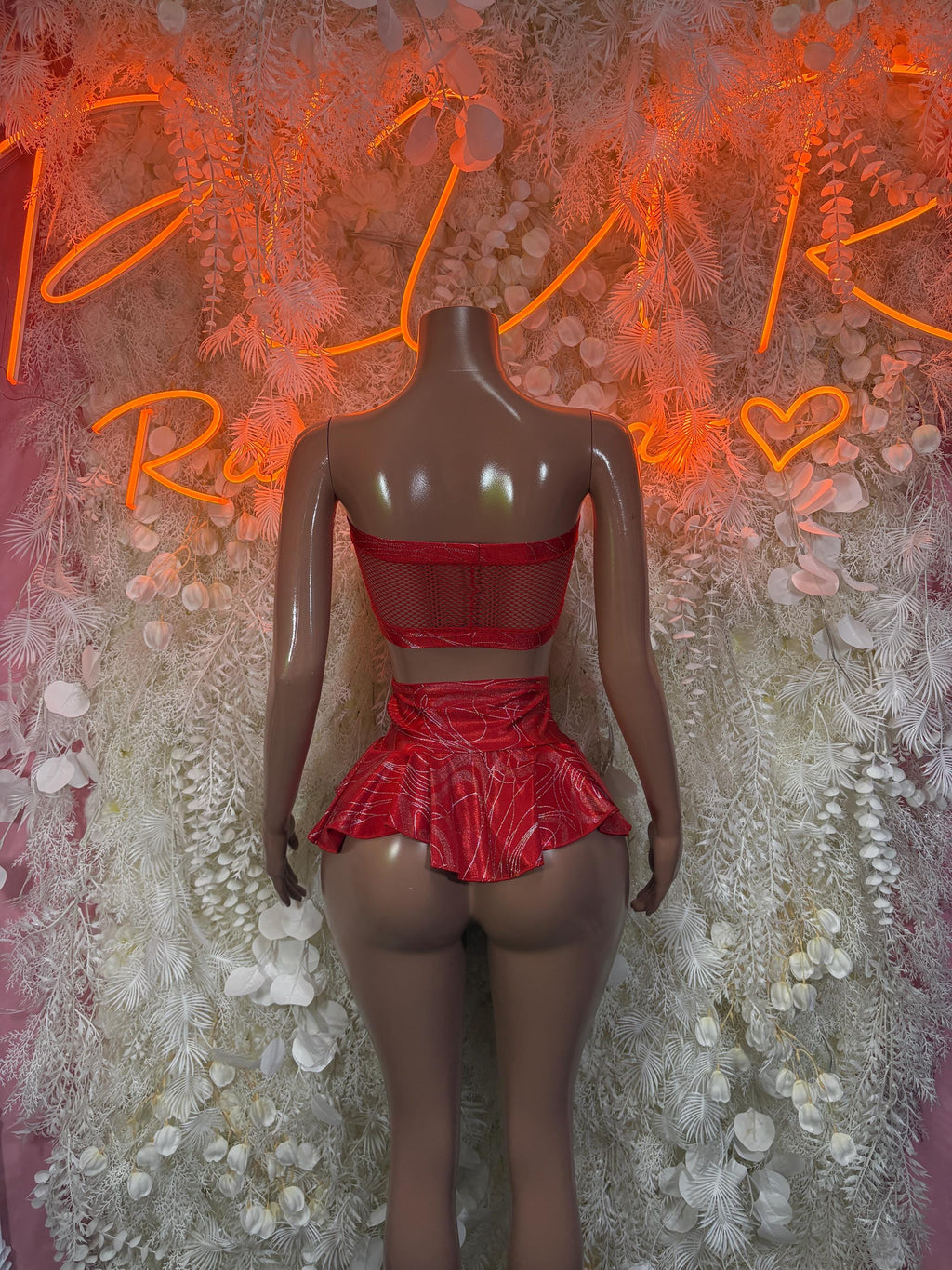 Red two-piece skirt set with mesh bandeau top, lace-up back, and ruffled mini skirt