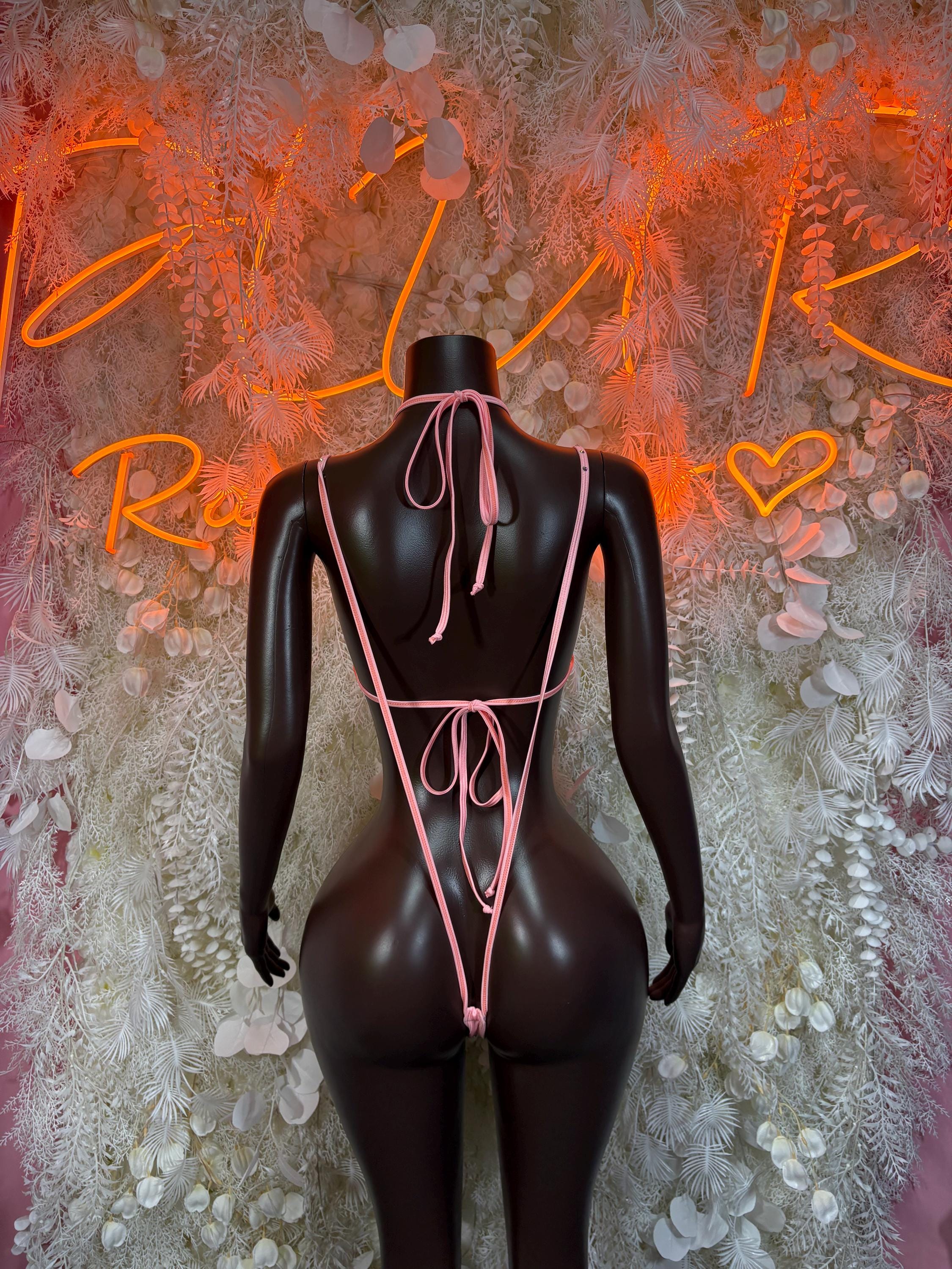 Back view pink slingshot-style costume with crisscross string ties and high-cut bottoms