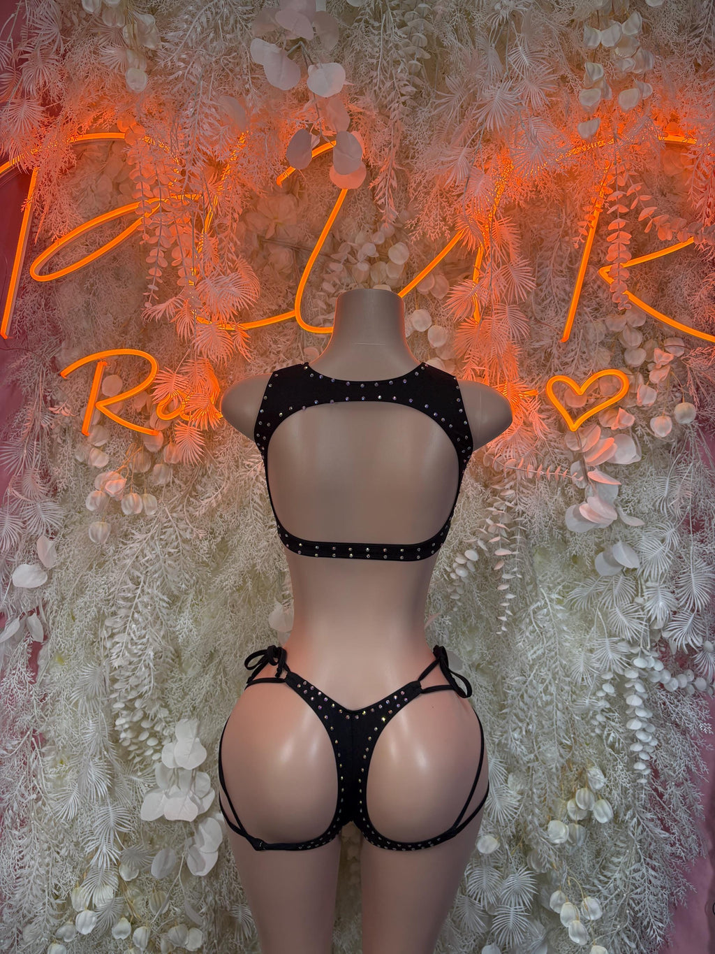 Black rhinestone backless bra and lace-up garter-style underwear on mannequin