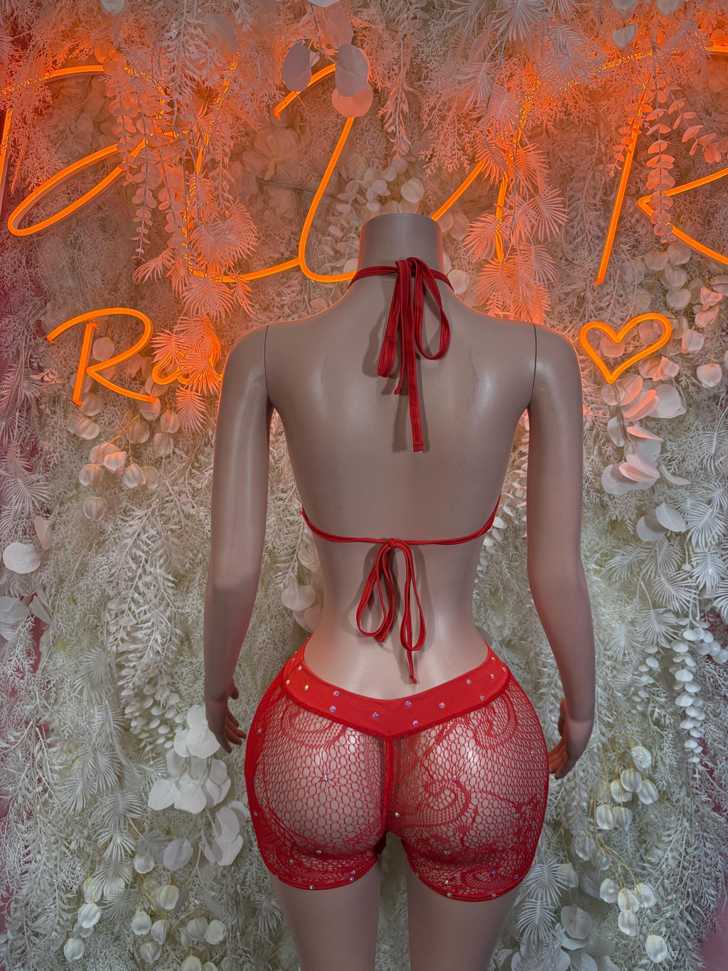 Red fishnet bodysuit with bow-tie straps on back and matching short shorts, back view