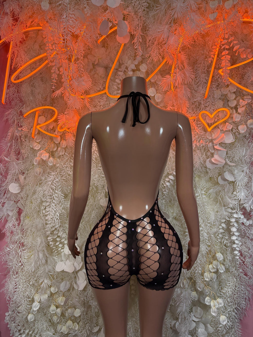 Black fishnet bodysuit with open back and tied bow at neckline