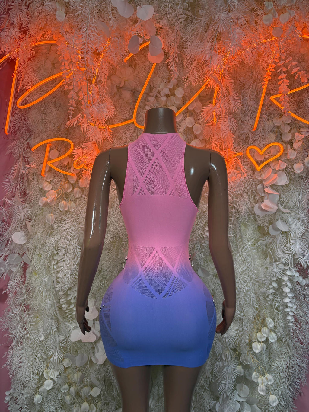 Back of fishnet one-piece clubwear dress, pink and blue gradient with crisscross straps