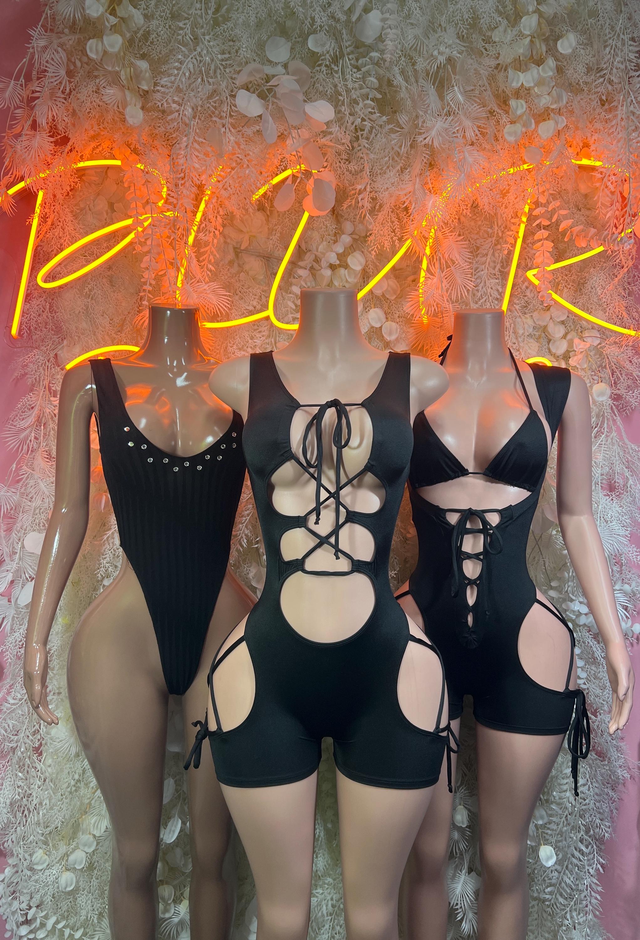 Three black cutout bodysuits, each with lace-up details and tie straps