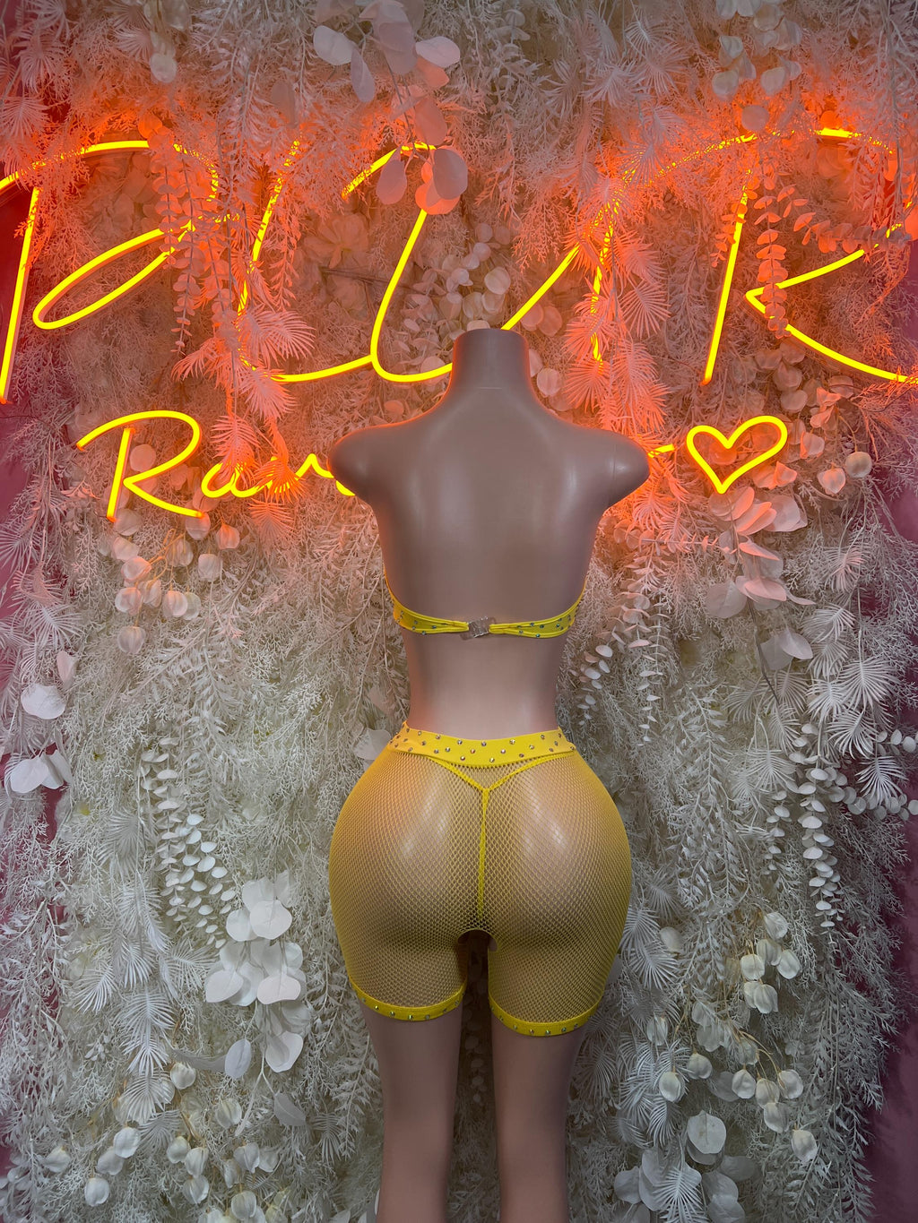 Yellow fishnet one-piece bodysuit with high-cut shorts and thin contrast trim.