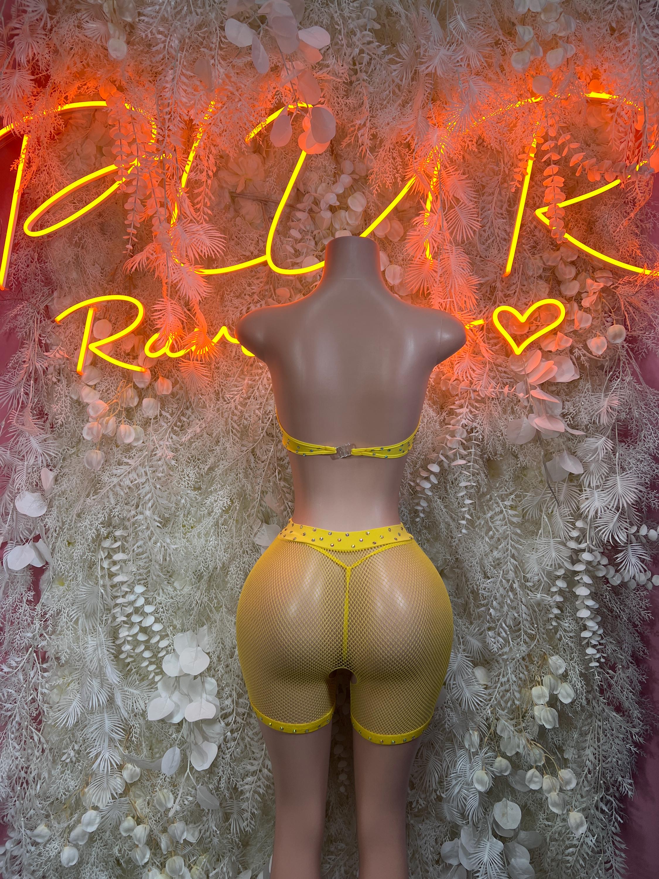 Yellow fishnet one-piece bodysuit with high-cut shorts and thin contrast trim.
