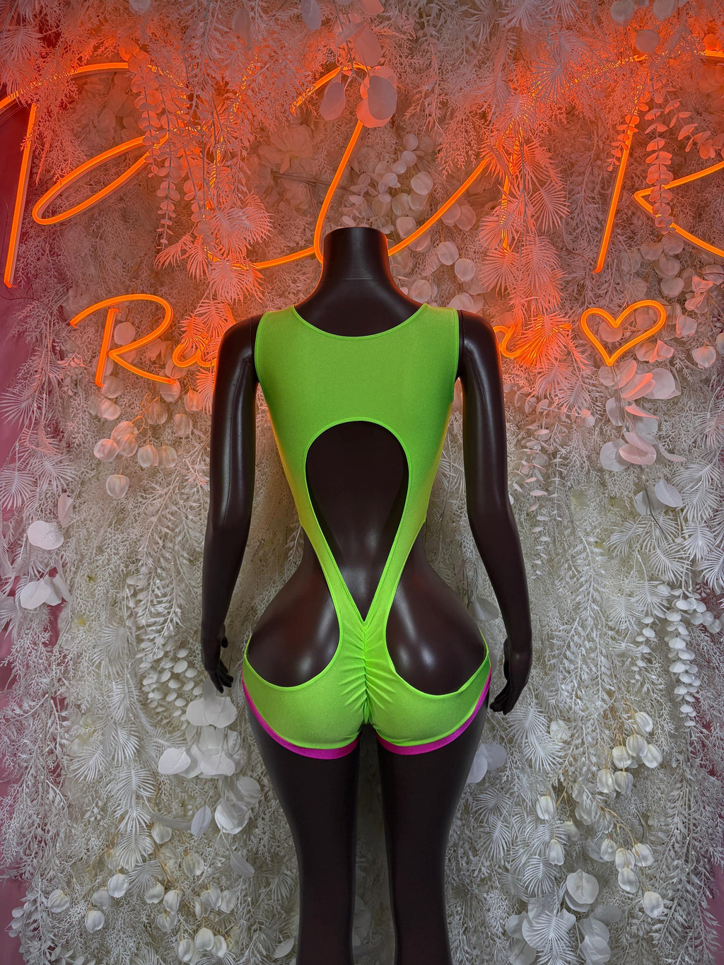 Green backless rave bodysuit with pink trim and large central cutout