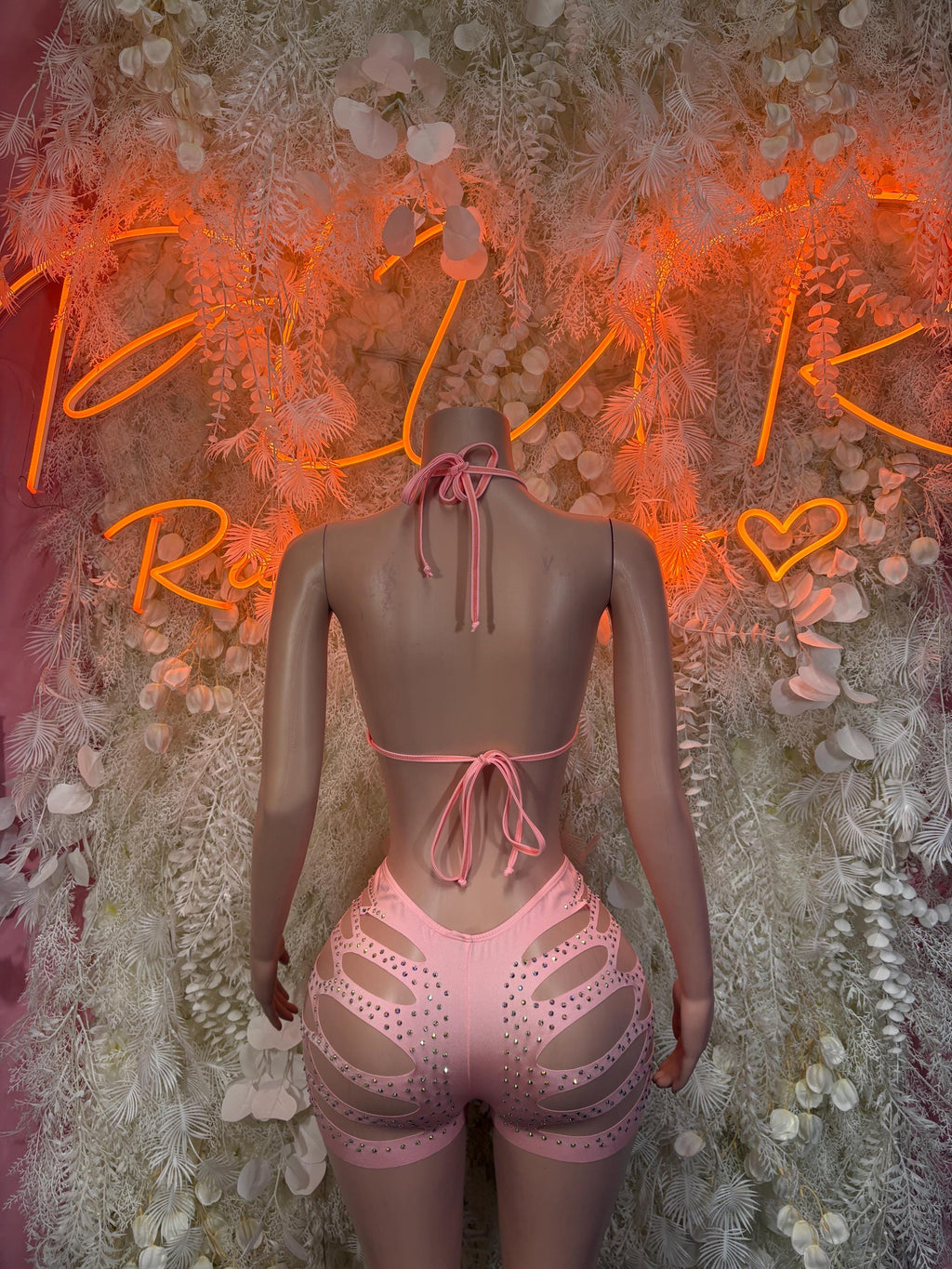 Pink backless halter bra with tied straps and matching rhinestone shorts set