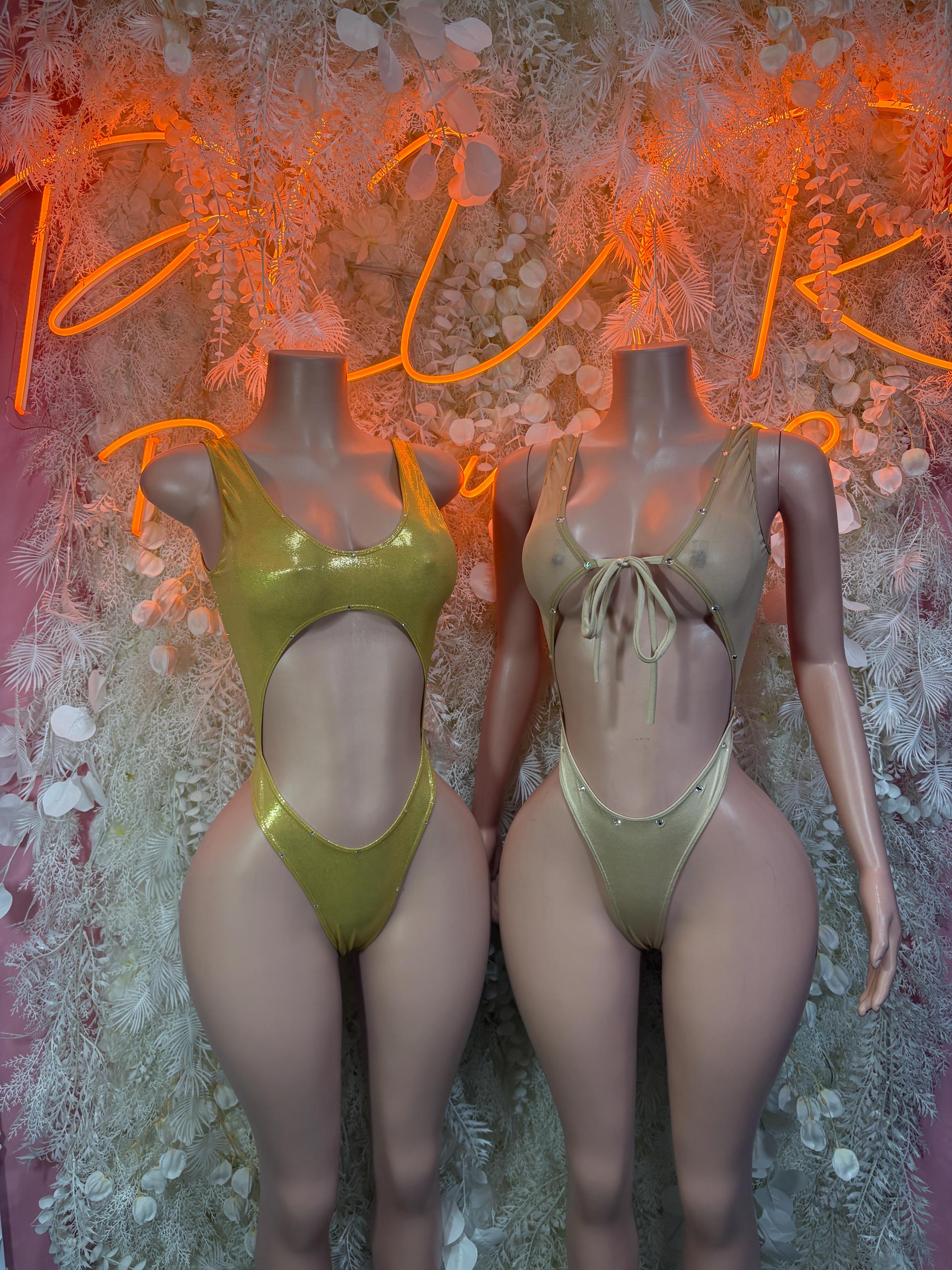 Gold rhinestone bodysuits on two models, one-piece halter style with high legs