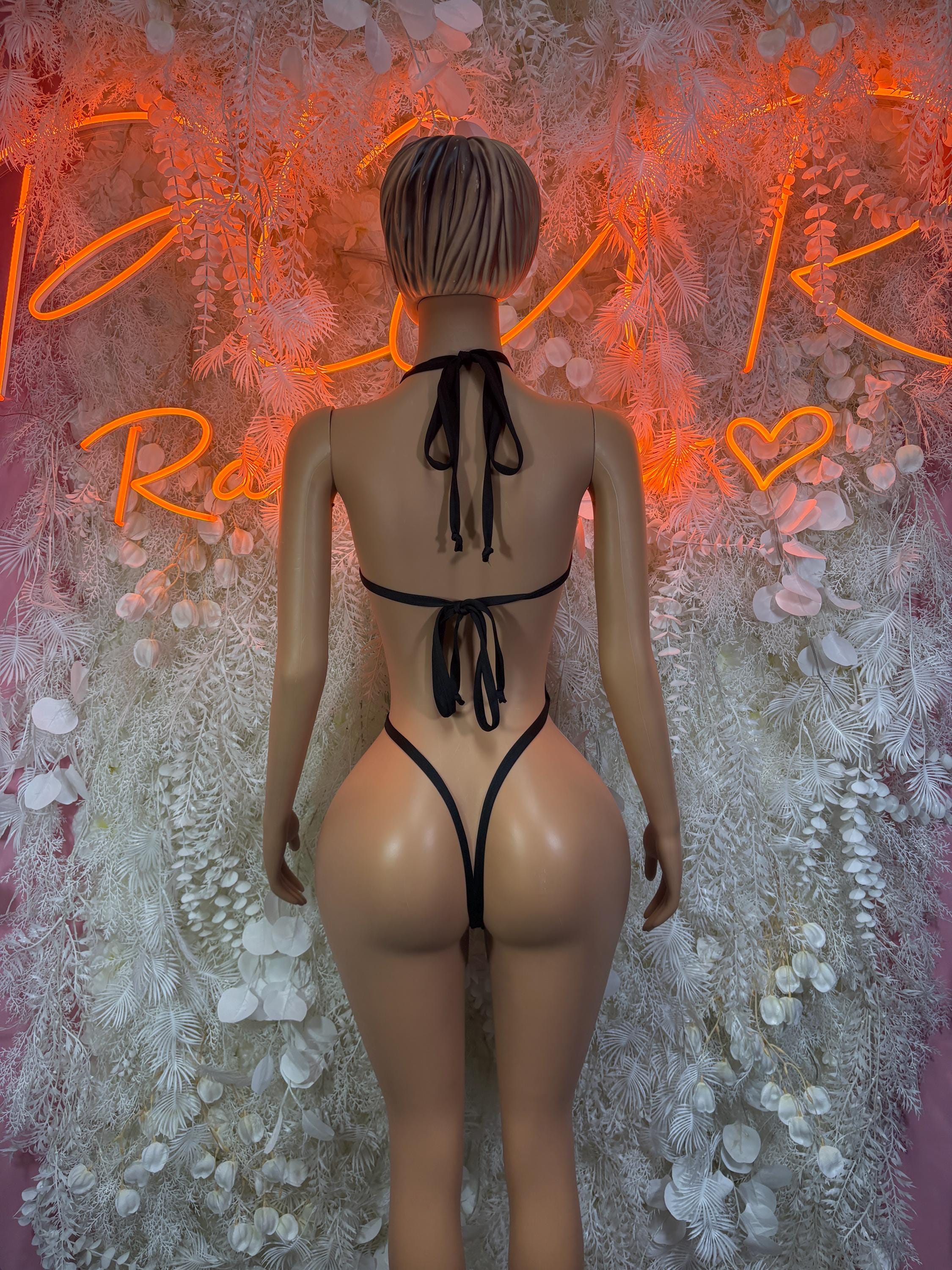 Back view of heart-print strappy rave bodysuit with black tie-back cords