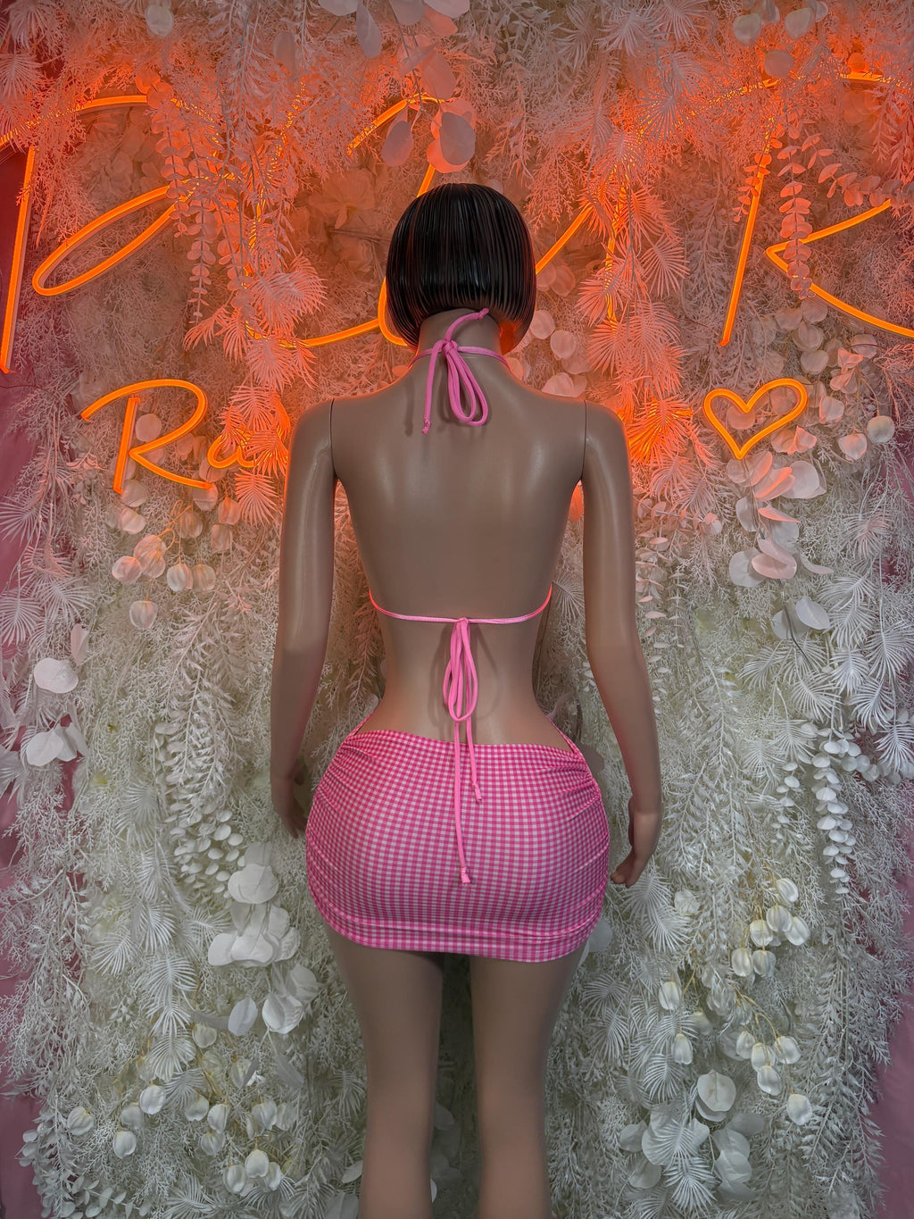 Pink checkered bikini top with tie-back straps and matching mini skirt, back view