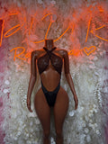 Black festival bodysuit with cross-back straps and pointed cutout front