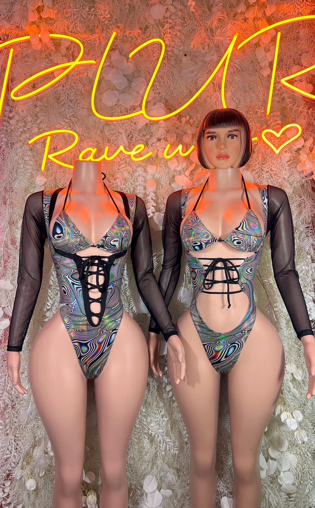 Rave bodysuit on model: black long sleeves, lace-up front, multicolor metallic print