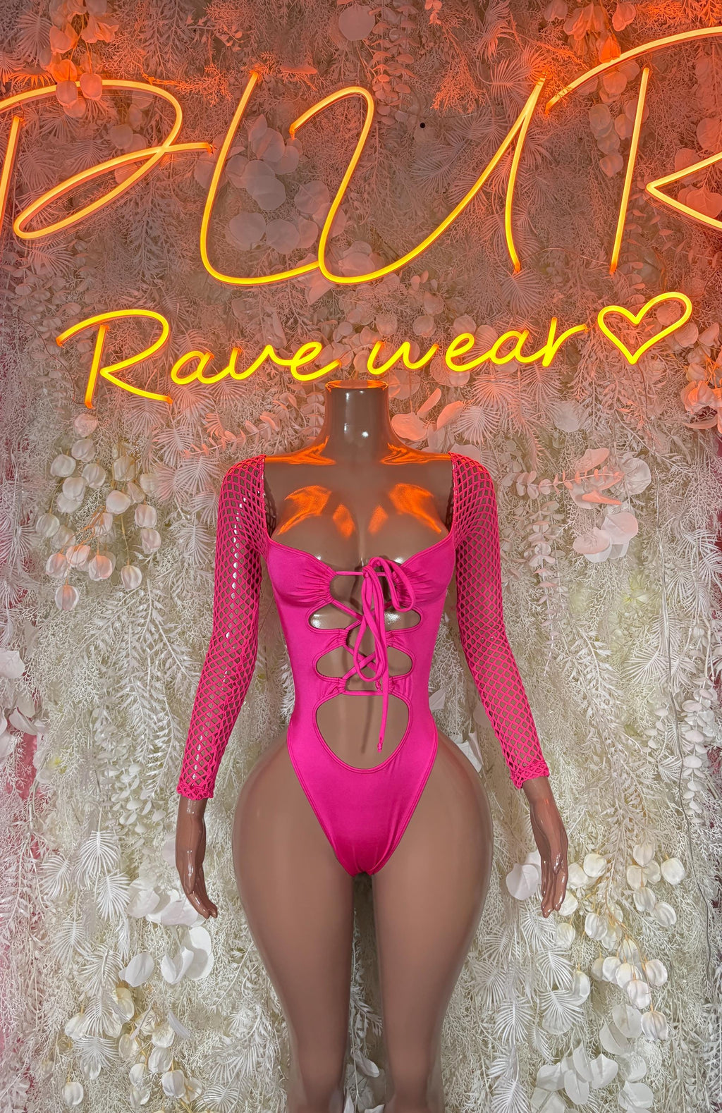 Pink one-piece rave bodysuit with long mesh sleeves and lace-up front