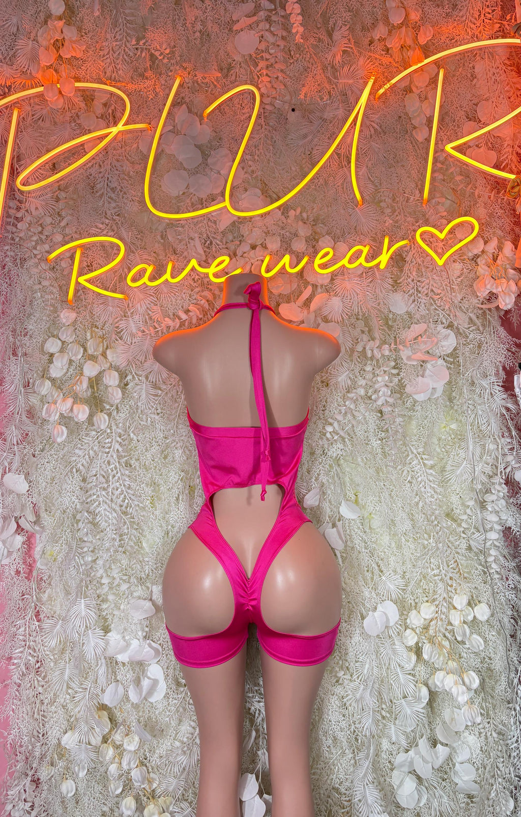 Pink fishnet bodysuit with crossed back straps and high-cut shorts