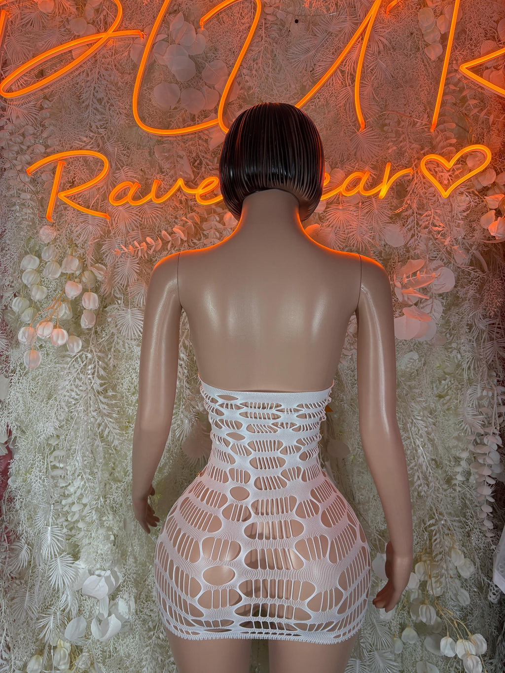 White fishnet mini dress, back view with circular cutouts and crisscross straps