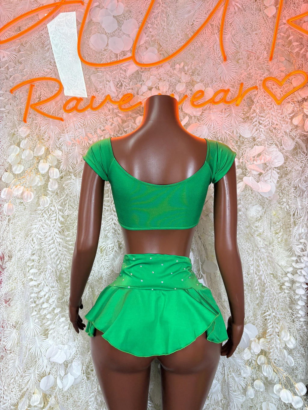 Green two-piece skirt set with open-back cropped top and layered flounce mini skirt