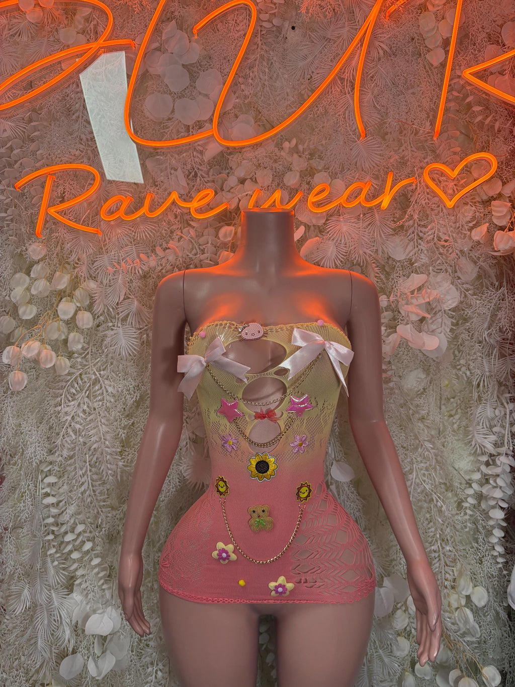 Pink mesh fishnet dress with multicolor pinned charms and white bow straps
