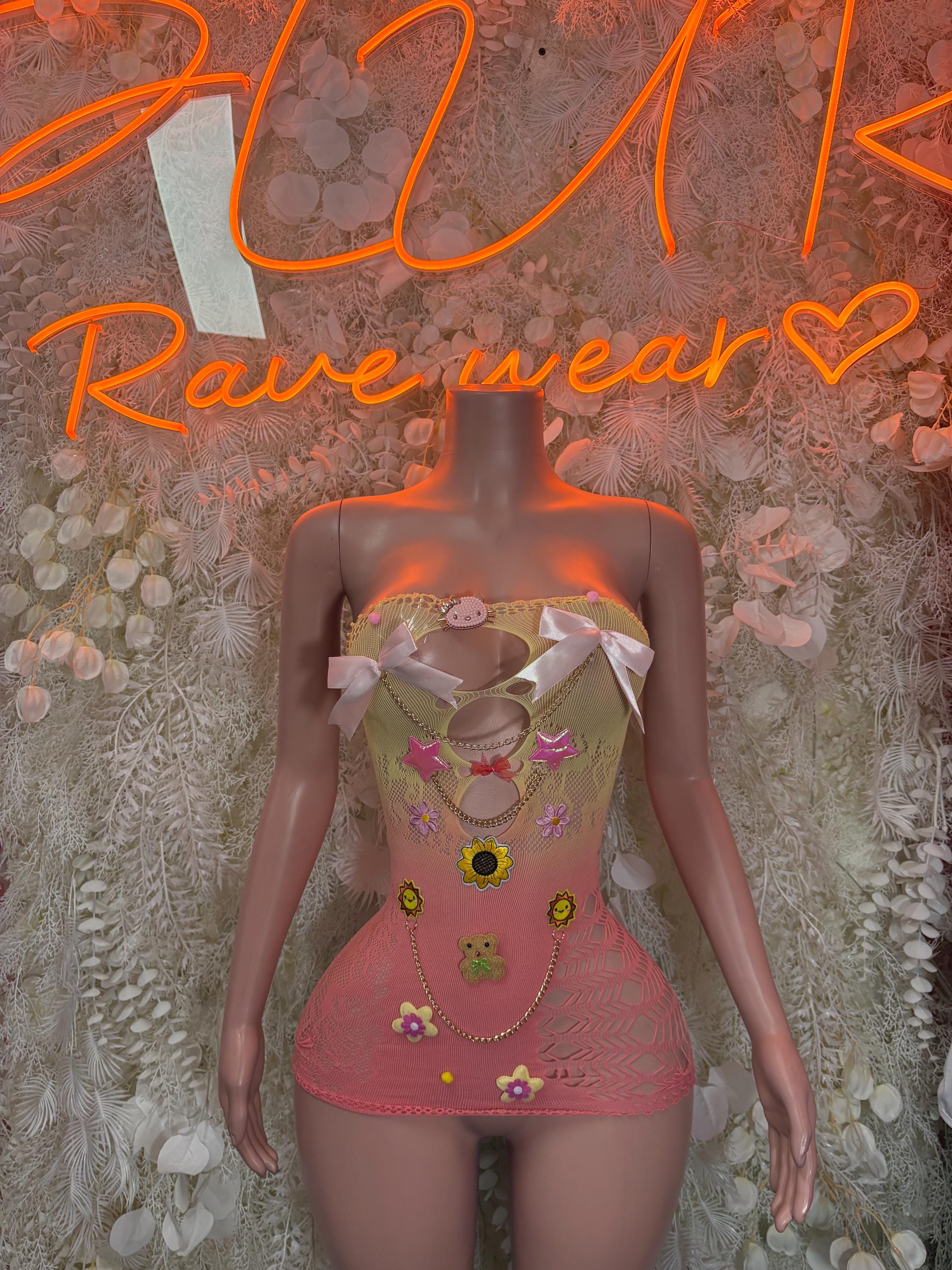 Pink mesh fishnet dress with multicolor pinned charms and white bow straps