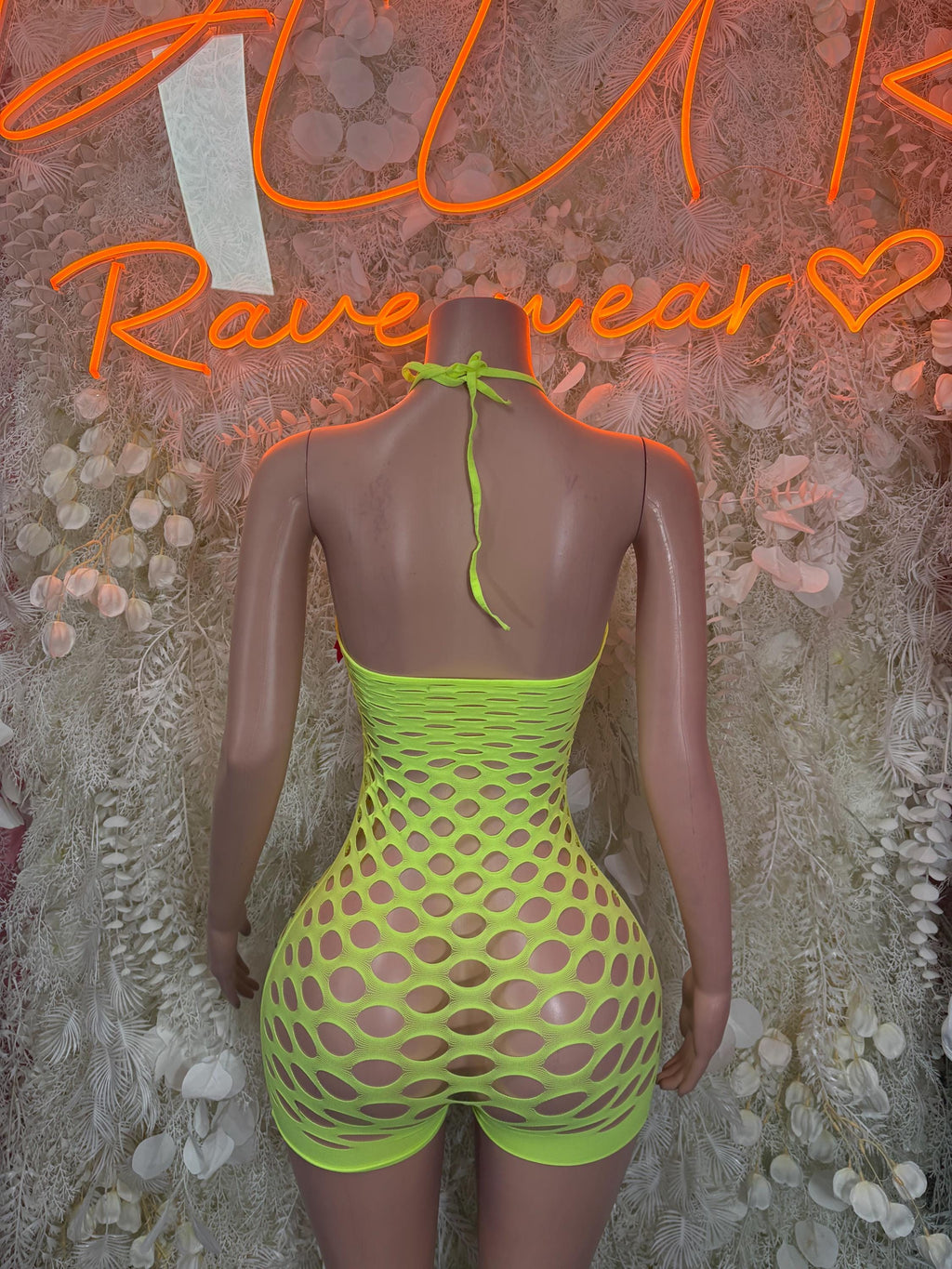 Neon green fishnet bodysuit, open back with thin tie straps and high-cut shorts