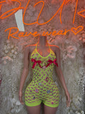 Neon green fishnet bodysuit with red bow appliques at bust and high-cut legs