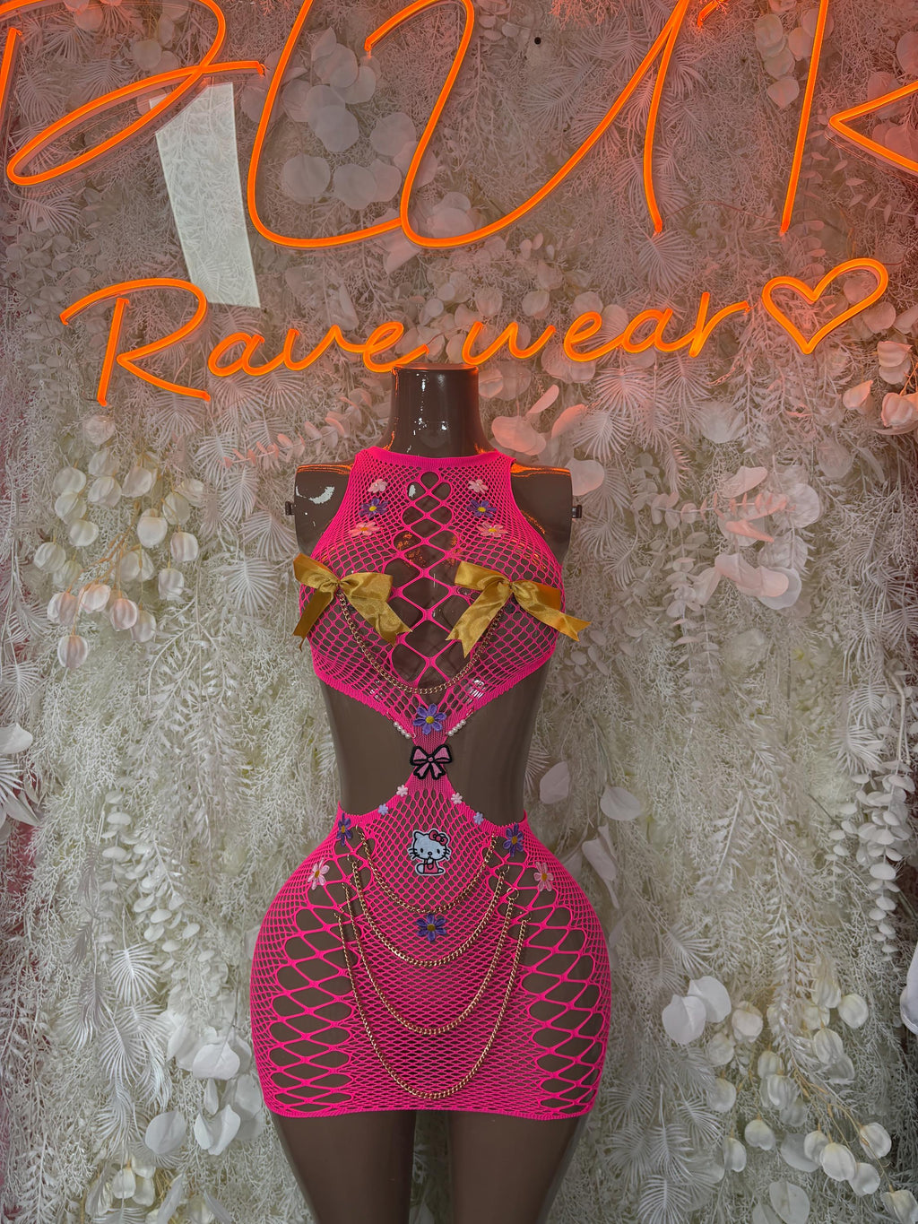 Pink fishnet bodysuit with diamond pattern and matching skirt overlay on mannequin
