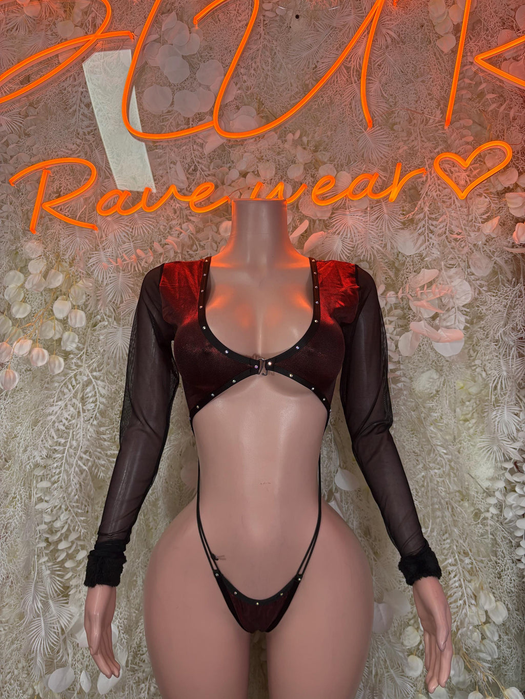 Dark one-piece dancewear outfit with long mesh sleeves, bra top, and thong bottom