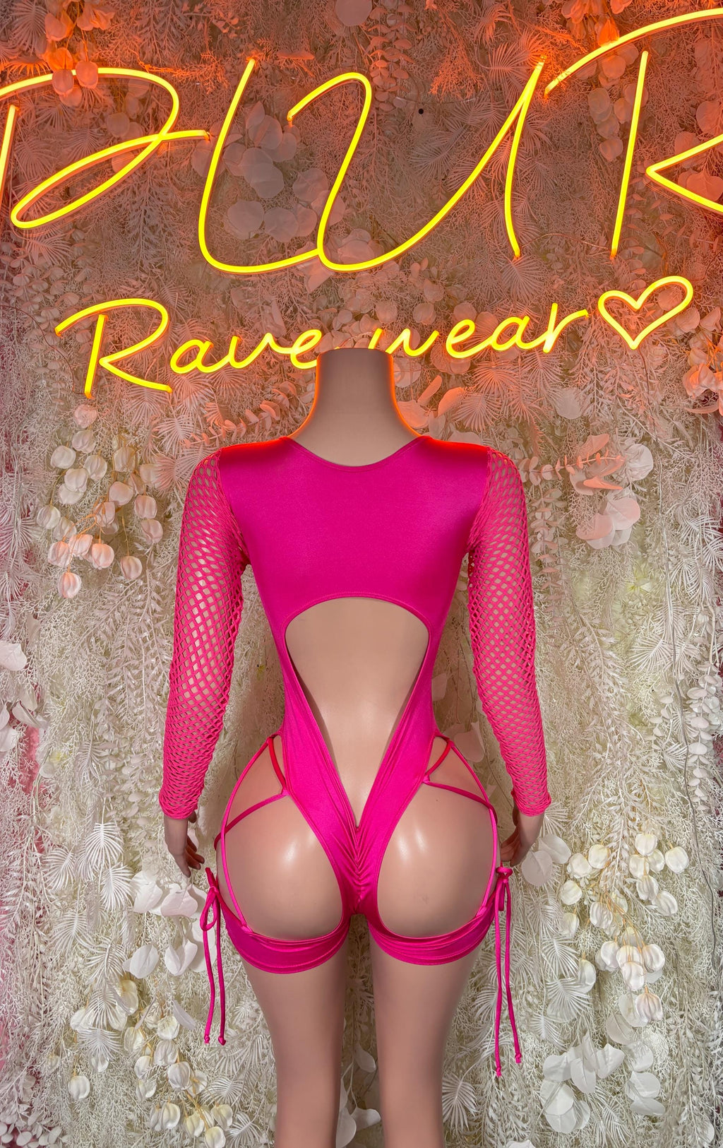 Pink rave bodysuit with long fishnet sleeves, deep cutout back, lace-up thigh ties