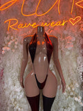 Black strappy bodysuit with cutout bust, garter straps, and thigh-high stockings